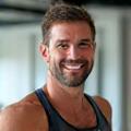 Energetic male fitness trainer with weights